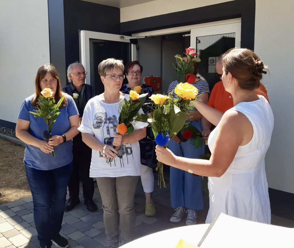 Frau Giebel überreicht dem neuen Angehörigen- und Betreuer*innenbeirat Blumen.