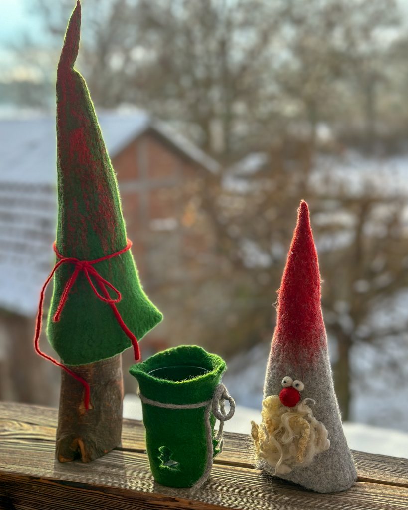 Ein Weihnachtsbaum, eine Windlicht und ein Weihnachtsmann aus Filz.