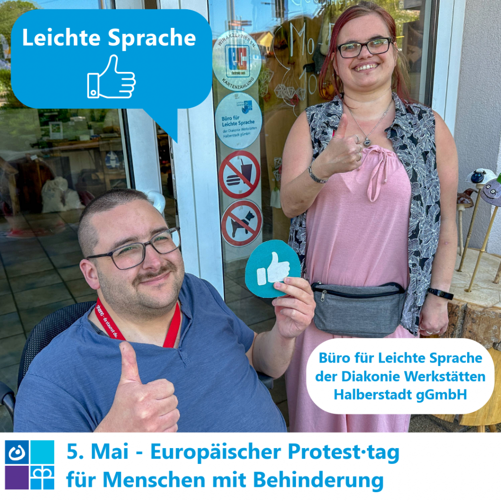2 Mitarbeiter vom Büro für Leichte Sprache zeigen eine Daumen hoch für Leichte Sprache