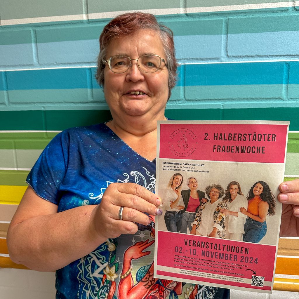 die Frauenbeauftragte von den Diakonie Werkstätten Halberstadt zeigt das Werbeplakat für die Frauenwoche in Halberstadt